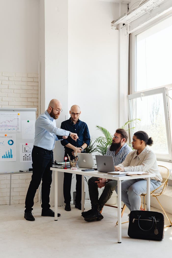 Business team working together in an office with laptops and charts.
